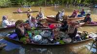 Pedagang melayani pembeli di atas perahu tradisional saat dibukanya Pasar Apung di kawasan Situs Candi Astano yang terendam banjir yaitu Kawasan Cagar Budaya Nasional (KCBN) Muara Jambi, Muaro Jambi, Jambi, Minggu (28/1/2024).