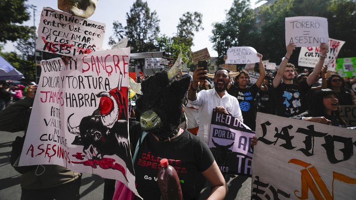 Police block a gate as animal rights activists try to enter the Plaza Mexico, in Mexico City, Sunday, Jan. 28, 2024. Bullfighting returned to Mexico City after the Supreme Court of Justice overturned a 2022 ban that prevented these events from taking place in the capital. (AP Photo/Fernando Llano)
