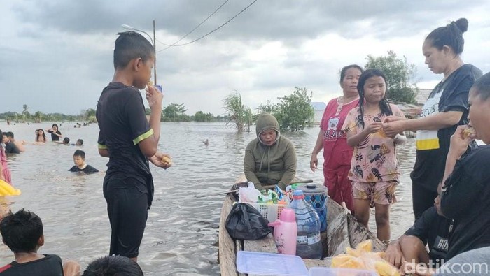 Anak-anak di Keramasan, Kertapati, Palembang jadikan kawasan banjir sebagai wahana main air.