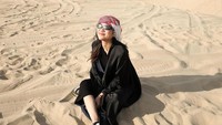 Mengenakan abaya berwarna hitam dan kacamata berwarna senada, Zize bak Oase penyejuk di tengah gurun pasir Qatar yang panas dan gersang. (Instagram/@azizahsalsha_)