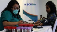 Petugas mengecek tekanan darah karyawan BCA Life yang akan mendonorkan darahnya.