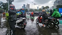 Banyak pemotor yang menepi untuk memakai jas hujan.