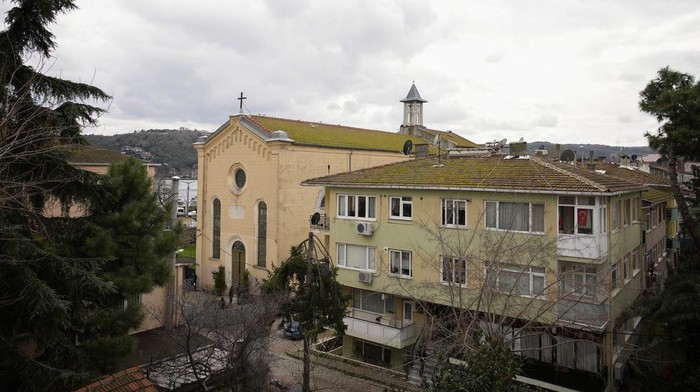 Ini Gereja yang Diserang Dua Pria Bertopeng di Turki Turkish police officers guard a cordoned off area outside Santa Maria church, left, in Istanbul, Turkey, Sunday, Jan. 28, 2024. Two masked assailants attacked a church in Istanbul during Sunday services, killing one person, Turkish officials said. (AP Photo/Emrah Gurel)