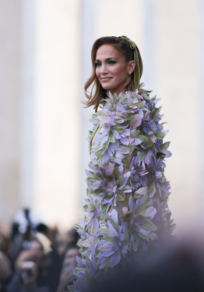 Jennifer Lopez memesona dengan gaun sage karya Elie Saab. Istri Ben Affleck itu melengkapi penampilannya dengan cape atau jubah bunga yang membuat gayanya semakin glamour. Foto: Jeremy Moeller/Getty Images