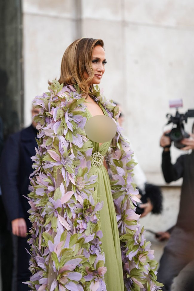 Penampilan J-Lo mencuri atensi karena gaun sage yang dipakainya memiliki belahan dada yang sangat rendah. Gaun tersebut dilengkapi belt atau ikat pinggang bordir. Foto: Edward Berthelot/Getty Images