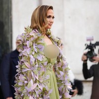 Penampilan J-Lo mencuri atensi karena gaun sage yang dipakainya memiliki belahan dada yang sangat rendah. Gaun tersebut dilengkapi belt atau ikat pinggang bordir. Foto: Edward Berthelot/Getty Images