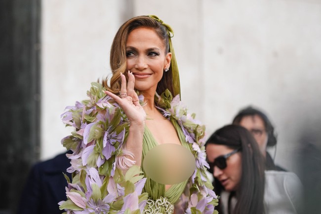 Aktris 54 tahun itu menata rambutnya dengan belahan samping, di mana di satu sisinya dihiasi pita hijau sage senada dengan warna gaunnya. Foto: Edward Berthelot/Getty Images