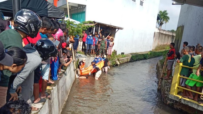 Petugas mengevakuasi mayat pria penuh luka yang ditemukan mengapung di saluran irigasi, Kelurahan Karangsentul, Kecamatan Padamara, Kabupaten Purbalingga, Senin (29/1/2024).