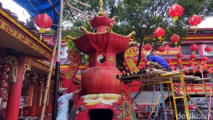 Sejumlah pekerja tengah melakukan pengecatan ulang dan mengganti lampu di Klenteng Eng An Kiong jelang Imlek, Senin (29/1/2024).