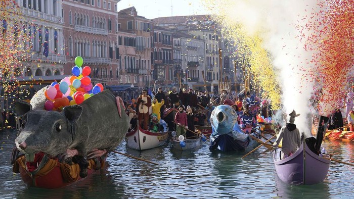 Boats sail as confetti explodes in the air during the traditional opening rowing parade, part of the Venice Carnival in Venice, Italy, Sunday Jan. 28, 2024. This year's edition 