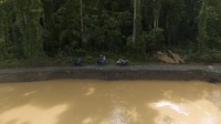 Dua pengendara sepeda motor melintas di samping jalan yang amblas akibat meluapnya sungai di Desa Sayoang, Pulau Bacan, Kabupaten Halmahera Selatan, Maluku Utara, Senin (29/1/2024).
