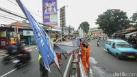 Petugas Satpol PP dan PPSU menurunkan sejumlah baliho Alat Peraga Kampanye (APK) di Jalan Raya Bogor, Kramat Jati, Jakarta Timur, Senin (29/1/2024).