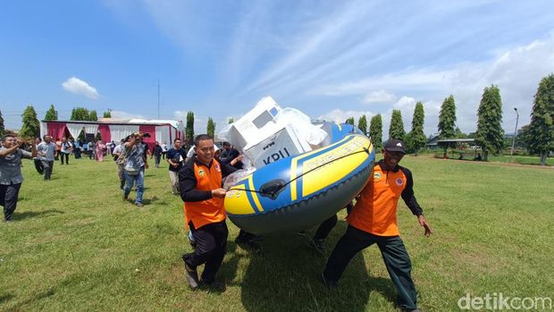 Petugas KPPS bersama dengan TRC dan BPBD Banyumas menyelamatkan kotak suara dalam simulasi pemungutan suara saat banjir melanda di Desa Gebangsari, Kecamatan Tambak, Kabupaten Banyumas, Minggu (28/1/2024).
