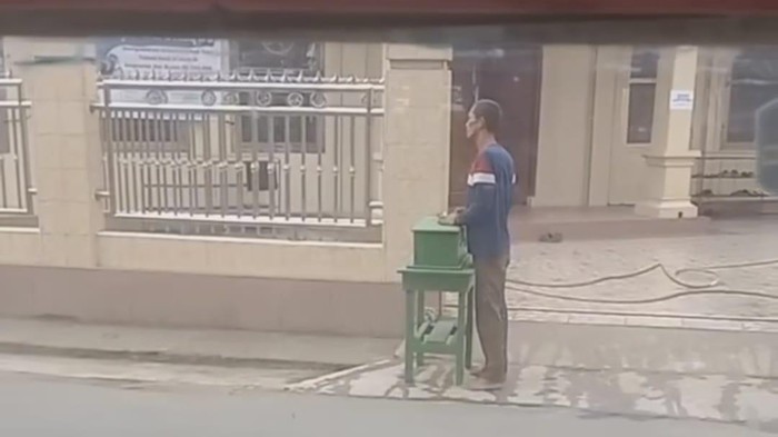 Pria di Palembang mencongkel kotak amal masjid dengan menggunakan lidi.