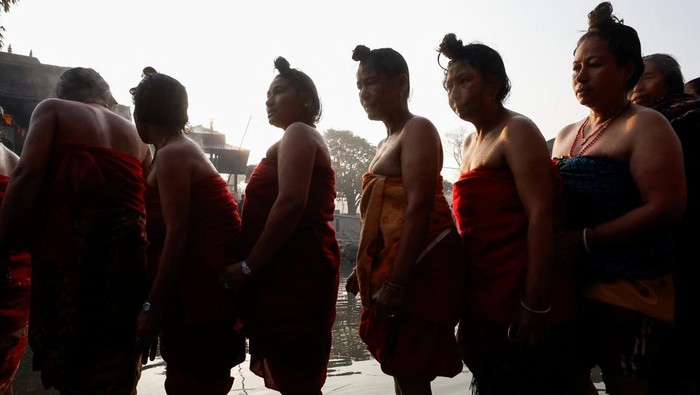 Devotees wait in a queue to offer prayer on the idol of God Madhav Narayan after taking a holy bath during the month-long Swasthani Brata Katha festival at the bank of Hanumante river in Bhaktapur, Nepal January 29, 2024. REUTERS/Navesh Chitrakar