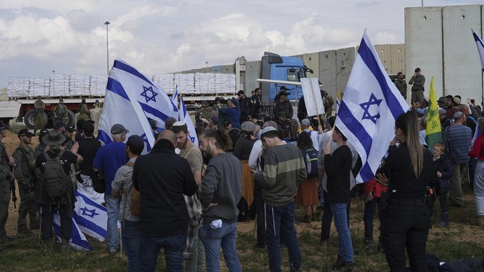 Aksi Warga Israel Blokir Jalan Truk Bantuan ke Palestina Israeli police prevent activists from blocking trucks carrying humanitarian aid into the Gaza Strip at the Kerem Shalom border crossing between Israel and Gaza, in southern Israel, Monday, Jan. 29, 2024. The activists say no aid should enter the territory until Israeli hostages held captive by the Hamas militant group are released. (AP Photo/Tsafrir Abayov)