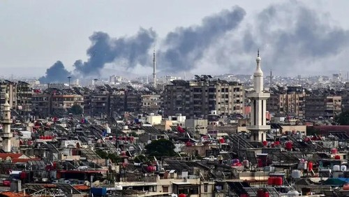 Smoke billows above buildings after an Israeli strike on the outskirts of Damascus, Syria, on November 22, 2023. (AFP)