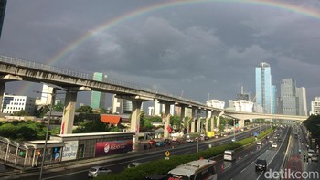 “Lokasi JPO Tegal Parang sekira jam 7.00 WIB. Kondisi gerimis lembut tapi ada Matahari dari sisi timur, langit barat dan utara gelap,” lapor Uyung, salah satu pembaca detikcom yang mengabadikan momen tersebut. Foto: AN Uyung Pramudiarja/detikcom