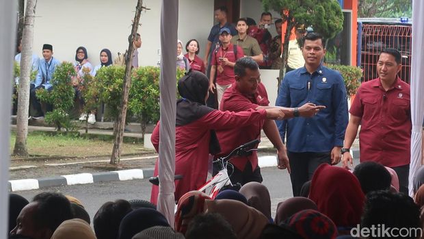Jokowi bagikan kaus dan sepeda di sela acara penyaluran bantuan beras di Gudang Bulog, Sendangsari, Kapanewon Pajangan, Kabupaten Bantul, DIY, Selasa (30/1/2024).