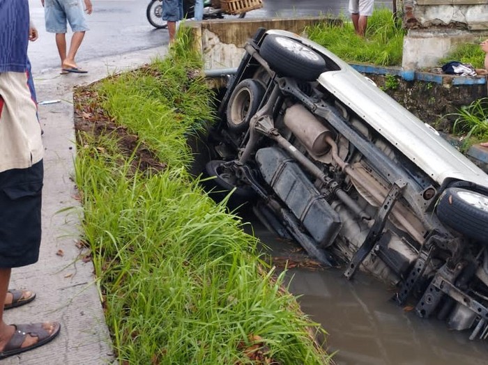 Mobil masuk ke saluran air di pinggir jalan raya Pundong Klegen, Panjangrejo, Kapanewon Pundong, Bantul, Selasa (30/1/2024).