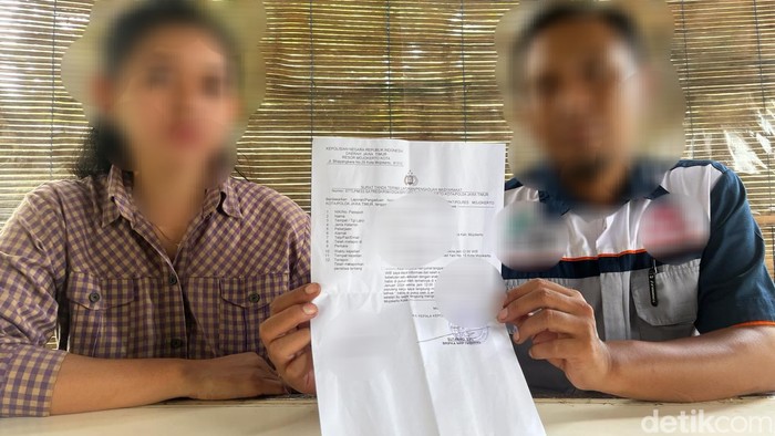 Orang tua korban menunjukkan surat tanda terima laporan dari Polres Mojokerto Kota
