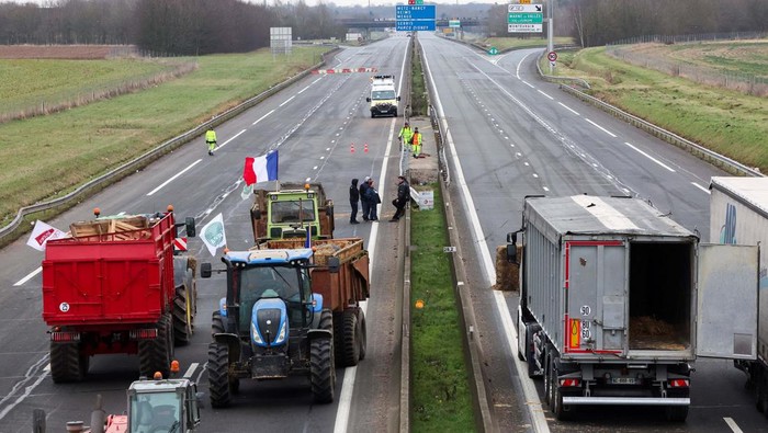 People gather during a blockade by farmers on the A4 highway to protest over price pressures, taxes and green regulation, grievances that are shared by farmers across Europe, in Jossigny, near Paris, France, January 30, 2024. REUTERS/Yves Herman