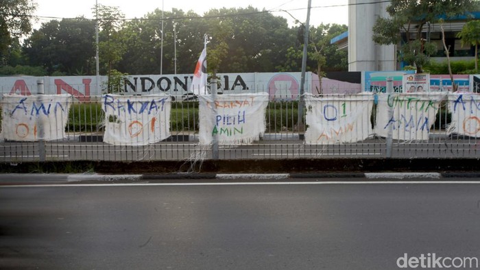 Spanduk AMIN dari Karung Penuhi Kawasan Taman Mini Spanduk dukungan terhadap Anies-Muhaiman berjejer di jalan Taman Mini, Jaktim. Spanduk tersebut tersebut dari karung dan ditulis tangan.