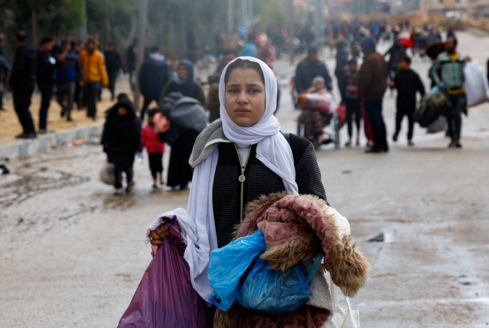 A woman holds a baby as Palestinians fleeing Khan Younis, due to the Israeli ground operation, move towards Rafah, amid the ongoing conflict between Israel and the Palestinian Islamist group Hamas, in the southern Gaza Strip, January 29, 2024. REUTERS/Mohammed Salem     TPX IMAGES OF THE DAY