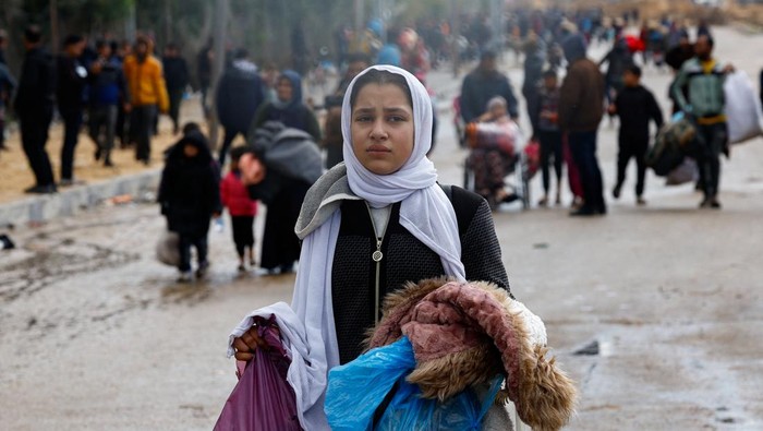 Warga Gaza Kabur ke Rafah Imbas Khan Younis Dibombardir Israel A woman holds a baby as Palestinians fleeing Khan Younis, due to the Israeli ground operation, move towards Rafah, amid the ongoing conflict between Israel and the Palestinian Islamist group Hamas, in the southern Gaza Strip, January 29, 2024. REUTERS/Mohammed Salem TPX IMAGES OF THE DAY