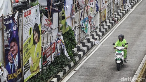 Pengendara melintas di antara deretan alat peraga kampanye berupa bendera partai politik, spanduk calon legislatif dan capres-cawapres di Mampang Prapatan, Jakarta Selatan, Rabu (31/1/2024). Tak sedikit APK yang berada di median jalan dan JPO tersebut lusuh, kotor maupun robek lantaran faktor cuaca dan sudah lama terpasang. Akibatnya, APK membuat kumuh dan merusak keindahan kota.