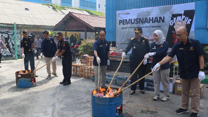 Bea Cukai saat melakukan pemusnahan jutaan rokok ilegal dan minuman keras. Dokumen Istimewa