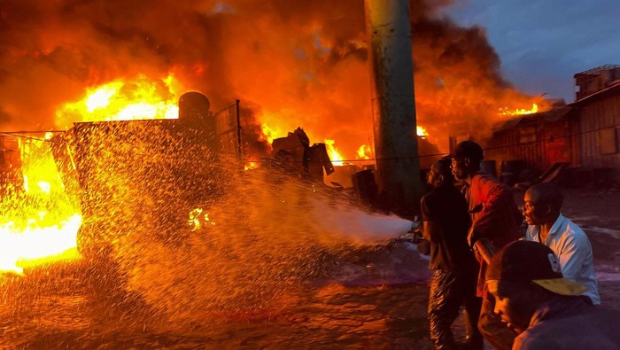 Volunteers attempt to extinguish a fire that broke out at a commercial depot, used for oil barrels and flammable drums, near Muthurwa settlement, in Nairobi, Kenya, January 30, 2024. REUTERS/Thomas Mukoya