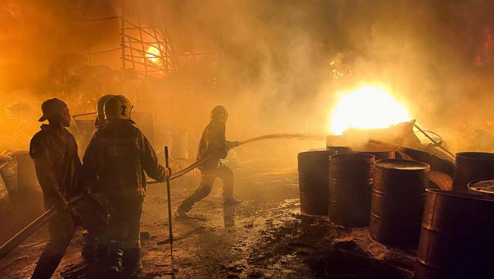Volunteers attempt to extinguish a fire that broke out at a commercial depot, used for oil barrels and flammable drums, near Muthurwa settlement, in Nairobi, Kenya, January 30, 2024. REUTERS/Thomas Mukoya