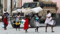 Warga membawa barang-barang saat meninggalkan rumah di bagian Pernier di Port-au-Prince, Haiti, Senin (30/1/2024).  