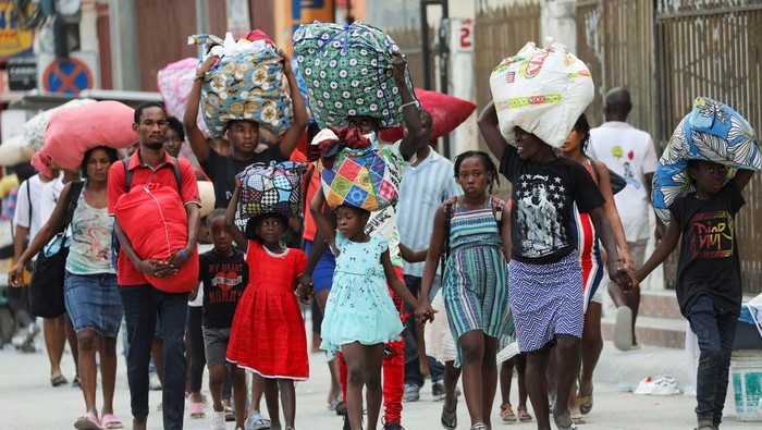 Hindari Geng Bersenjata, Warga Haiti Kabur dari Rumah Residents carry belongings as they leave their homes due to gang violence, in the Pernier section of Port-au-Prince, Haiti January 30, 2024. REUTERS/Ralph Tedy Erol