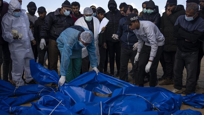 Palestinians bury the bodies of people who were killed in fighting with Israel and returned to Gaza by the Israeli military, during a mass funeral in Rafah, Gaza Strip, Tuesday, Jan. 30, 2024. (AP Photo/Fatima Shbair)