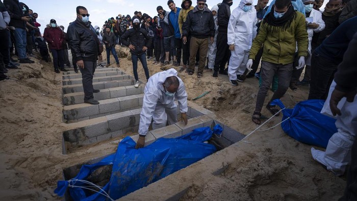 Palestinians bury the bodies of people who were killed in fighting with Israel and returned to Gaza by the Israeli military, during a mass funeral in Rafah, Gaza Strip, Tuesday, Jan. 30, 2024. (AP Photo/Fatima Shbair)