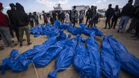Jenazah yang dibungkus plastik biru itu dibawa ke lokasi tujuan dengan truk pendingin.