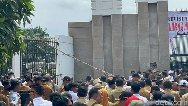 Massa demo Apdesi merusak tembok pagar DPR dengan palu besar.