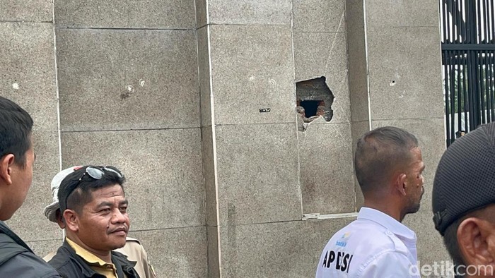 Massa demo Apdesi merusak tembok pagar DPR dengan palu besar.