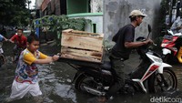 Selain orang dewasa, anak-anak juga ikut membantu mendorong motor yang mogok.