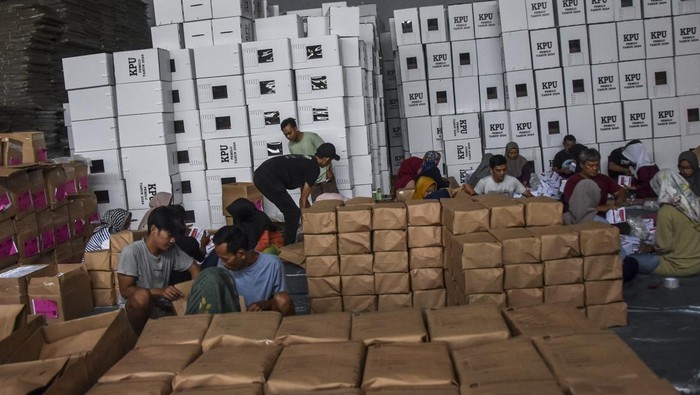 Polisi bersenjata berjaga di samping pekerja saat mengemas logistik Pemilu di Gudang Logistik, Imbanagara, Ciamis, Jawa Barat, Rabu (31/1/2023). KPU Ciamis melakukan pengaturan dan pengemasan logistik Pemilu 2024 untuk didistribusikan secara bertahap di 3.943 TPS pada 1-13 Pebruari 2024. ANTARA FOTO/Adeng Bustomi/nym.