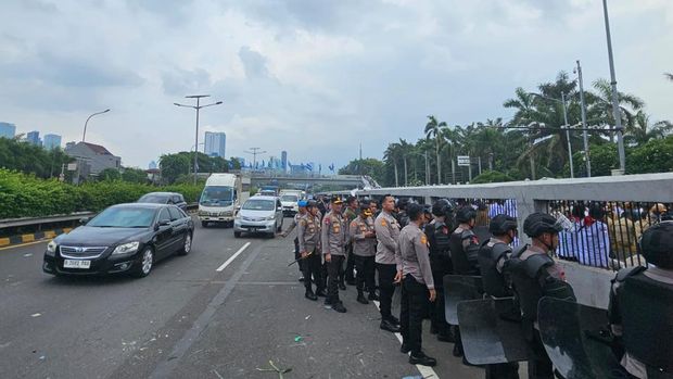 Polisi membentuk barisan mengamankan massa agar tidak masuk ke ruas jalan tol. Wakapolda Metro Jaya Brigjen Suyudi Ario Seto ikut turun menghalau massa.