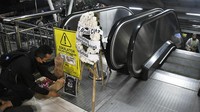 Karangan bunga duka cita itu diletakkan di eskalator yang mati.