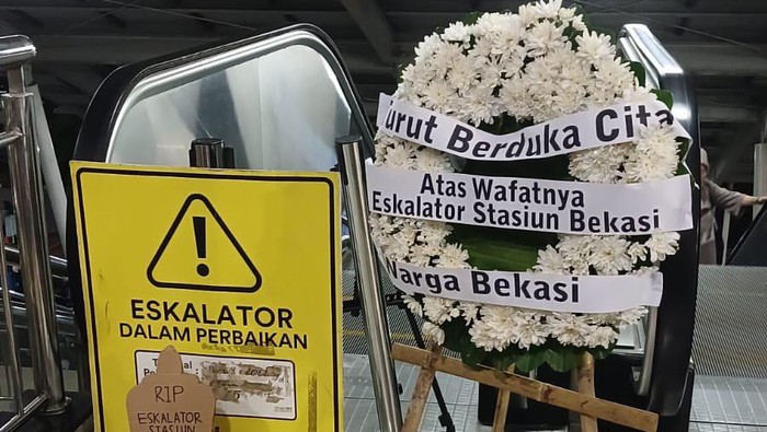 Aksi tebar bunga dan pasang nisan replika di Stasiun Bekasi memperingati 100 hari-an eskalator mati.