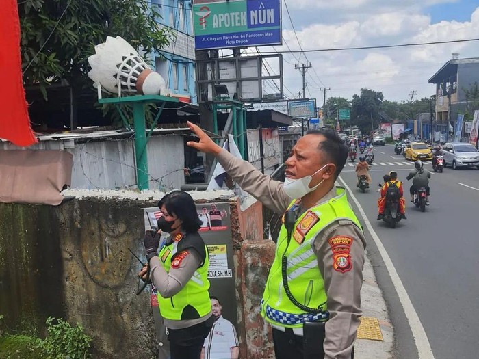Anggota Satlantas Polres Metro Depok menerima laporan dari masyarakat terkait kabel menjuntai di dekat jembatan Ratujaya untuk memastikan lalu lintas aman. (dok IG @lantasrestrodepok)