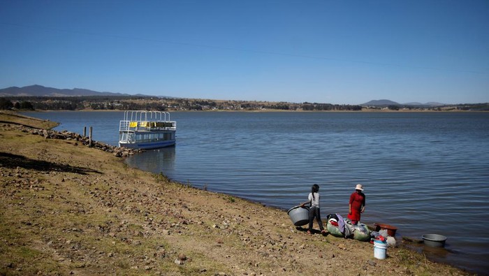 Dilanda Kekeringan, Warga Meksiko Manfaatkan Air Waduk yang Menyusut Women wash clothes on the shore of Villa Victoria Dam, part of the Cutzamala System collecting water for distribution into Mexico City and the metropolitan areas, in Villa Victoria, Mexico, January 26, 2024. REUTERS/Raquel Cunha