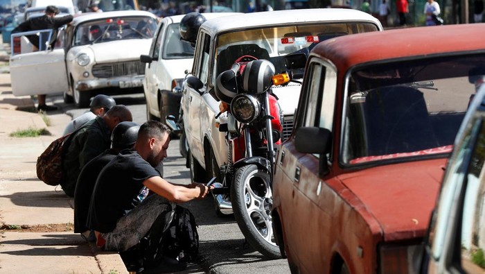 People stand in line with their cars to fill up on fuel after Cuba's government put off a five-fold increase in gasoline prices planned for February 1 due to a cyberattack, according to Economy Vice Minister Mildrey Granadillo, in Havana, Cuba January 31, 2024. REUTERS/Yander Zamora