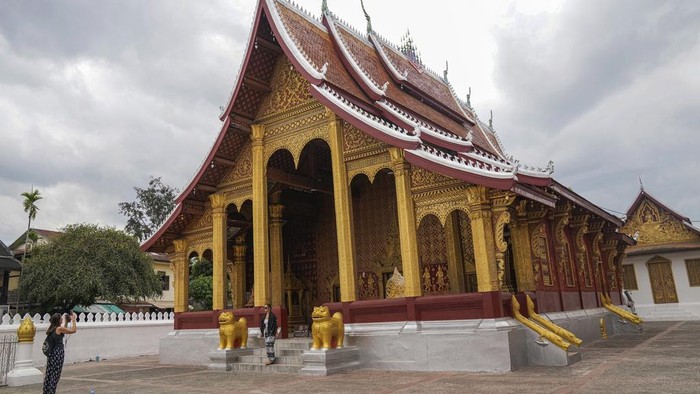 People offer food to Buddhist monks outside Sensoukharam temple in Luang Prabang, Laos, Sunday, Jan. 28, 2024. Luang Prabang was named a UNESCO World Heritage Site nearly 30 years ago, but a multibillion-dollar dam project is raising questions that c