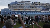 Orang-orang mengambil gambar dari South Pointe Park, saat Icon of the Seas, kapal pesiar terbesar di dunia, berlayar keluar dari Port Miami pada pelayaran umum pertamanya, di Miami Beach, Florida, Sabtu (27/1/2024).